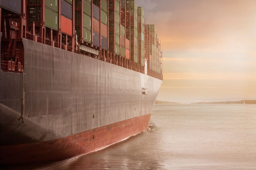 Crafting Captivating Headlines: Your awesome post title goes here A colossal cargo ship loaded with containers navigates through calm waters against a vibrant sunset sky.